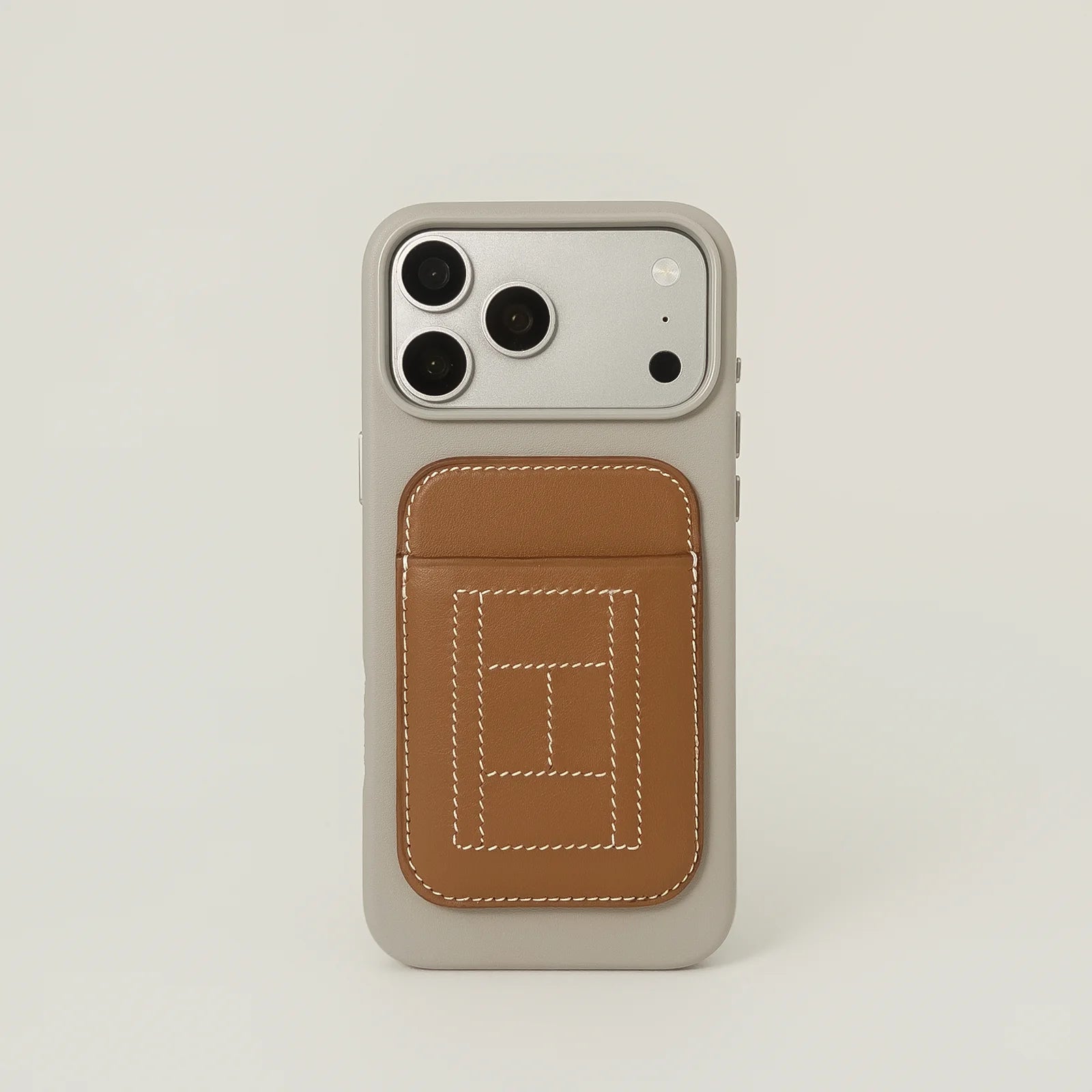 Phone case with a brown card holder on a light beige background